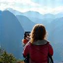 Junge Frau macht ein Foto von einer Berglandschaft
